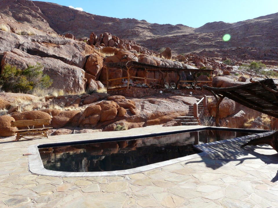 Pool mit Liegen und Schattenspender Fest Inn Fels Farm-Lodge