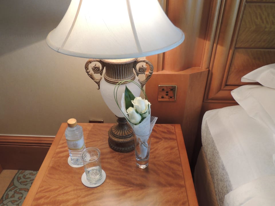 Nachttisch mit Begrüßungsblumen und Wasser Emirates Palace Mandarin Oriental