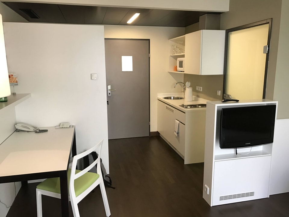 Zimmer mit TV, Schreibtisch und Küche Hotel Harry's Home Linz