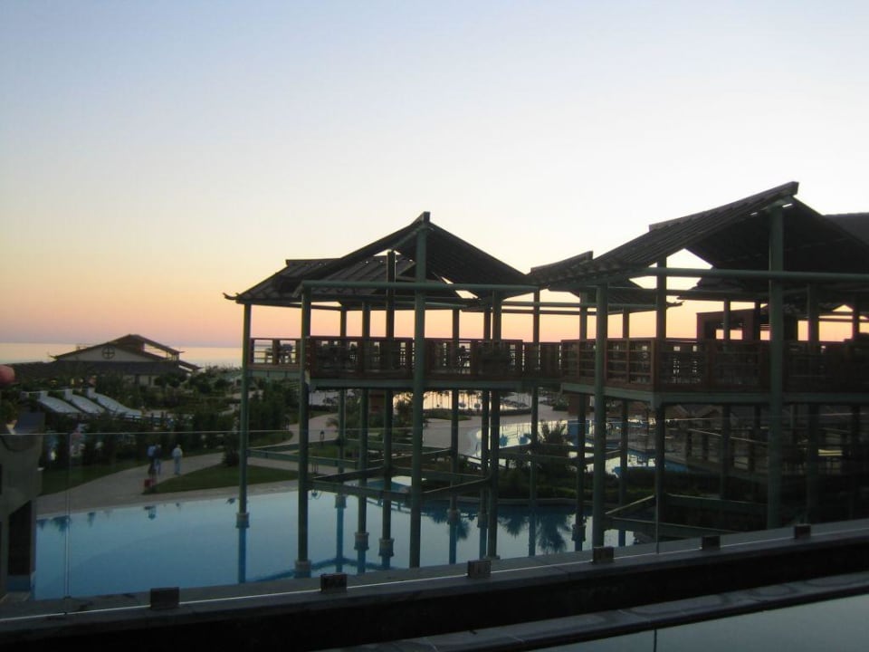 Poollandschaft bei Sonnenuntergang Limak Lara Deluxe Hotel & Resort