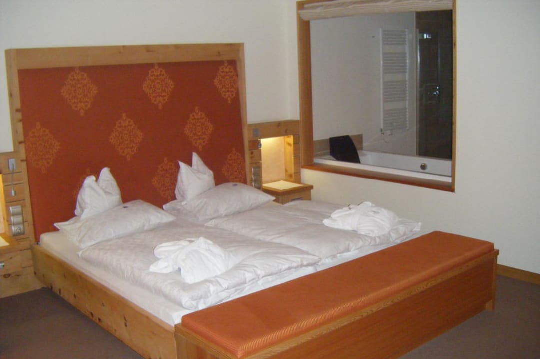 Bett mit Fensteröffnung zum Badezimmer Hotel Mein Almhof Superior