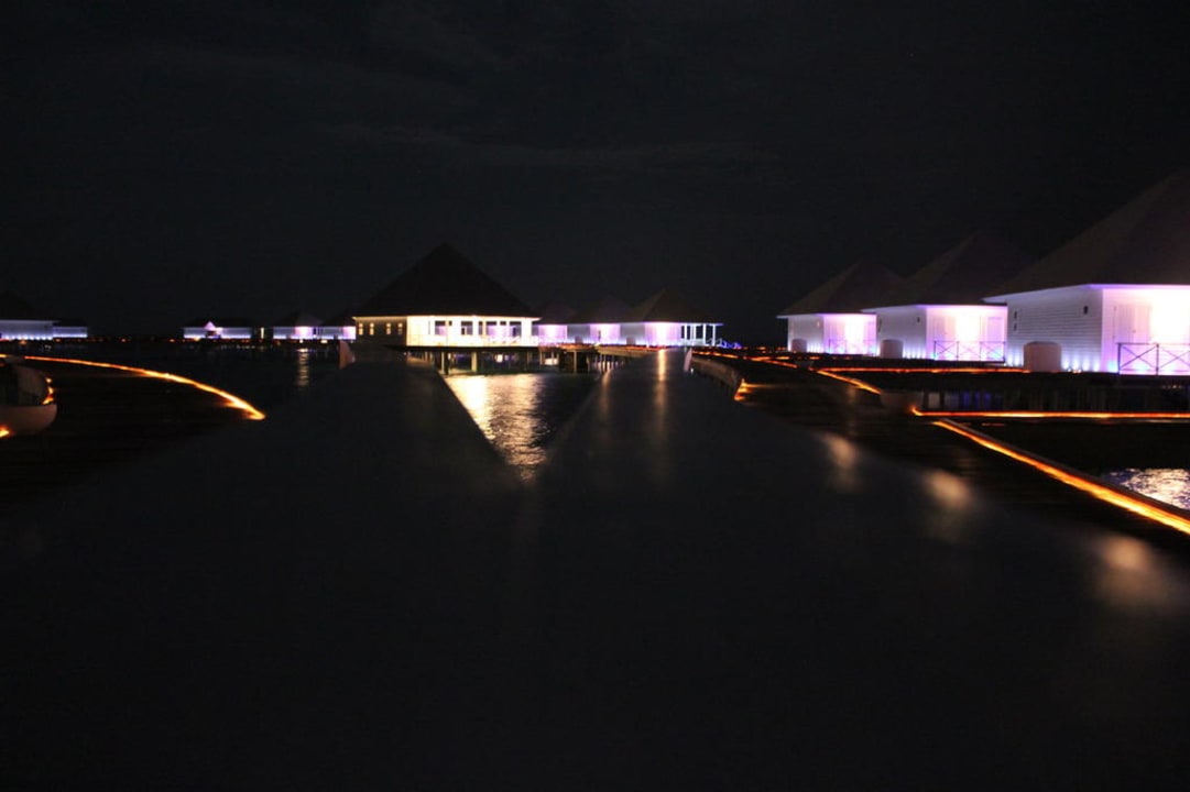 Der nächtliche Steg zu den Wasservillen Diamonds Thudufushi