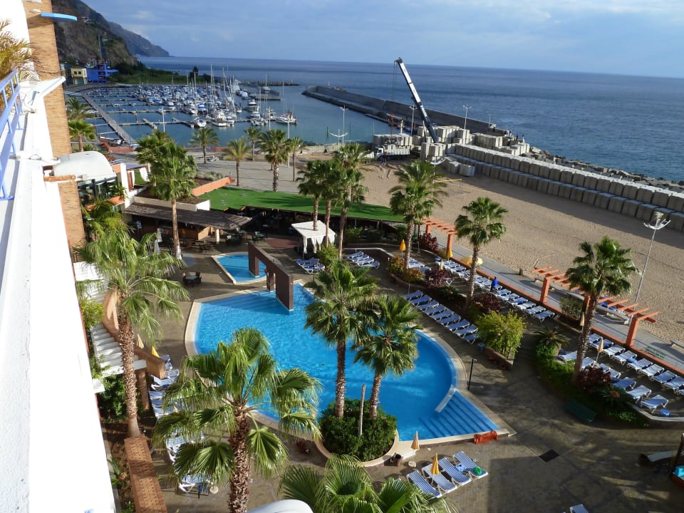 Poolanlage mit dahinterliegender Marina und Strand Calheta Beach