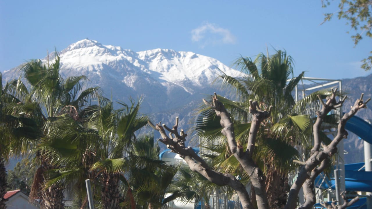 Blick vom Strandauf die schneebedeckten Berge Limak Limra Hotel & Resort