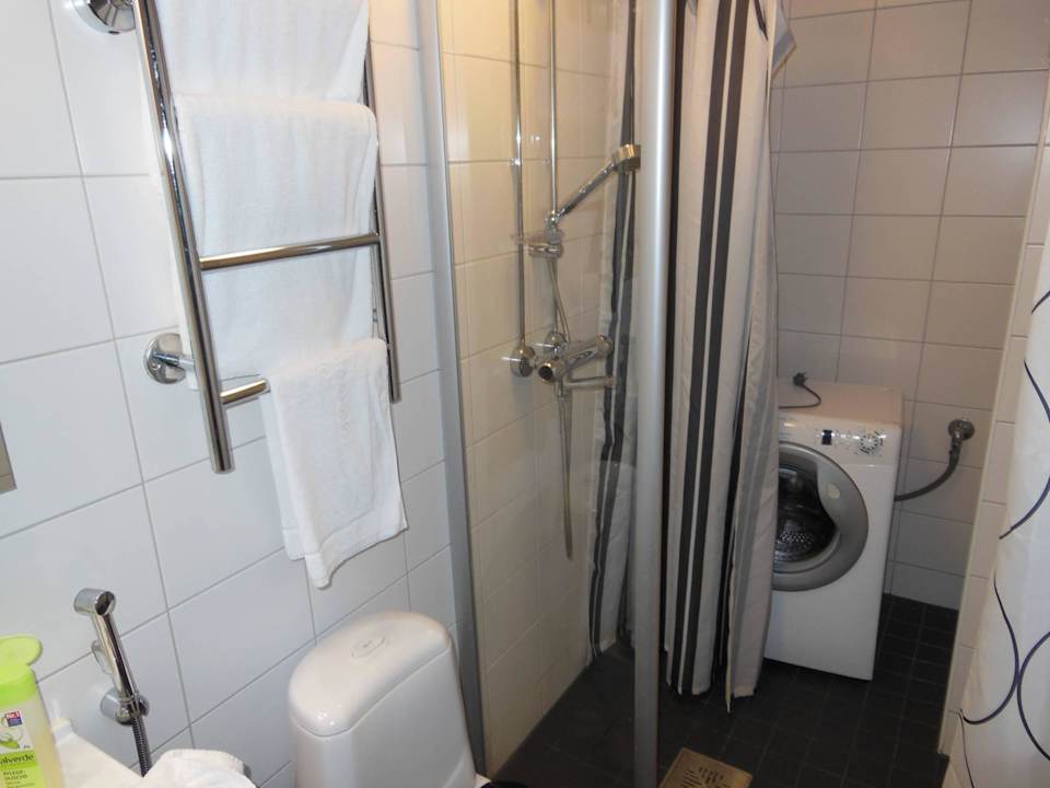 Dusche und Waschmaschine (hinter Duschvorhang) SATO HotelHome Lapinlahdenkatu