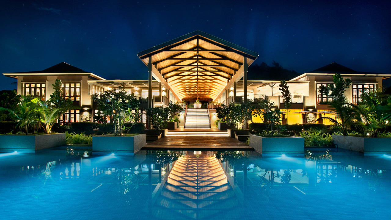Pool und Hauptbegäude bei Nacht Kempinski Seychelles Resort