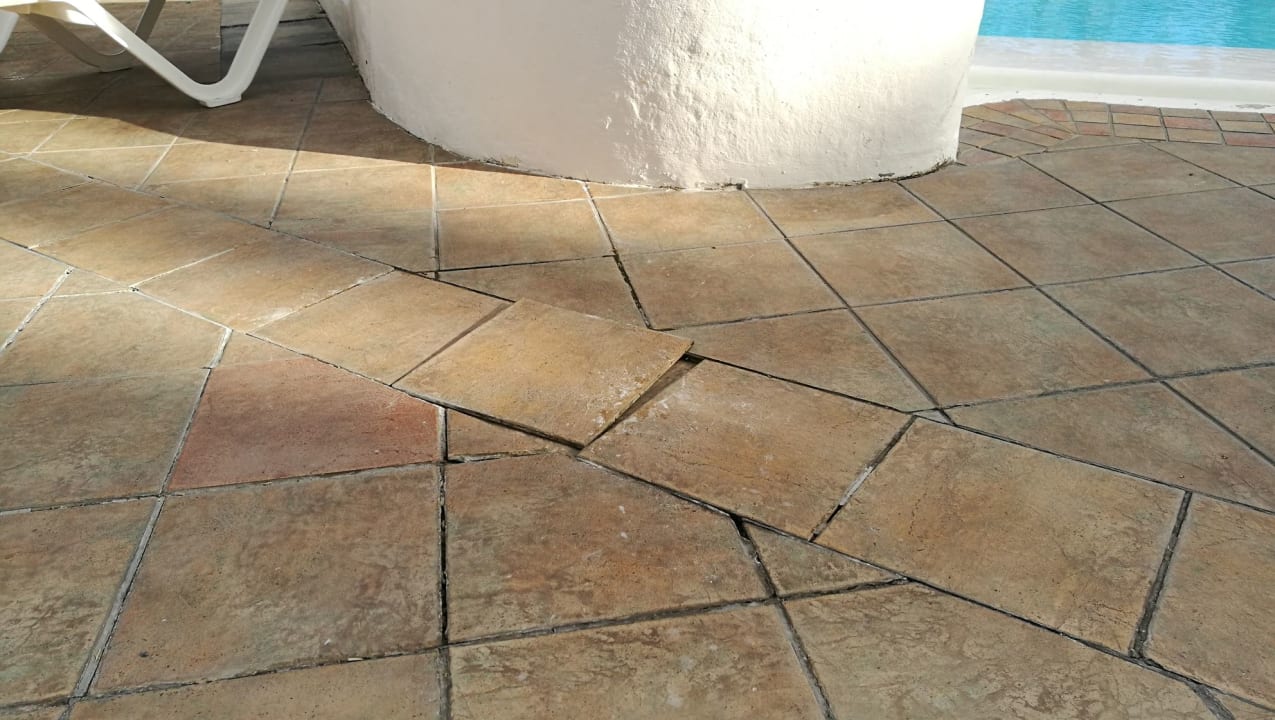 Offene Fugen und lose Fliesen am Pool HL Miraflor Suites Hotel