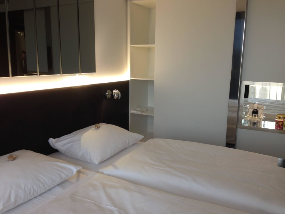 Blick auf Bett und Minibar Hotel AMANO Grand Central