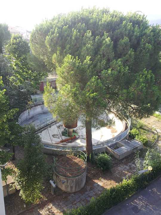 Zadní parkoviště u hotelu s odstavenou čistírnou Hotel Corolle