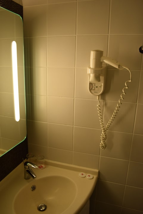 Badezimmer: Beleuchteter Spiegel und Föhn an der Wand ibis Hotel Ankara Airport