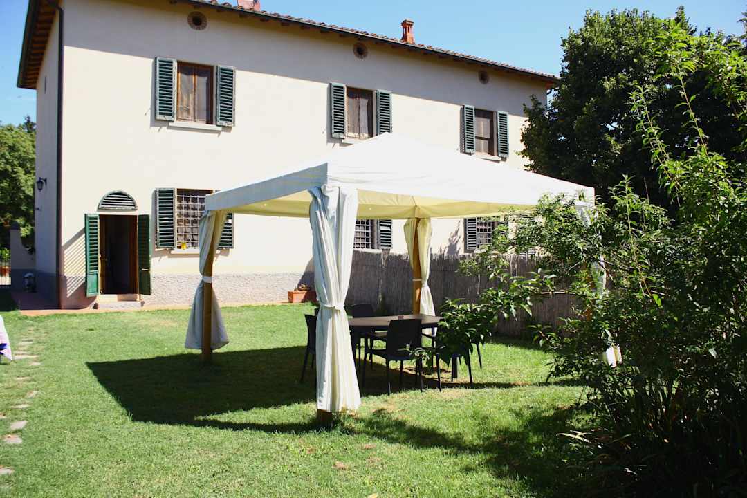 Pavillion mit Tisch und Stühlen, dahinter Eingang Appartamento Falegnameria