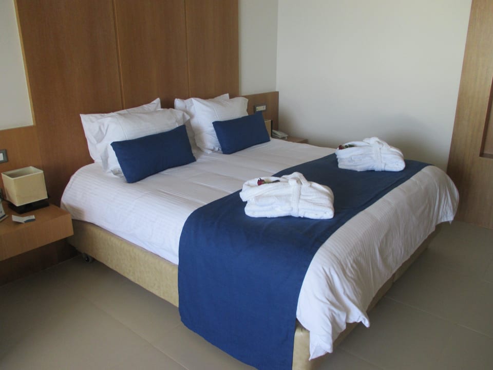 Bett mit Bademänteln und Rose darin Atlantica Kalliston Resort