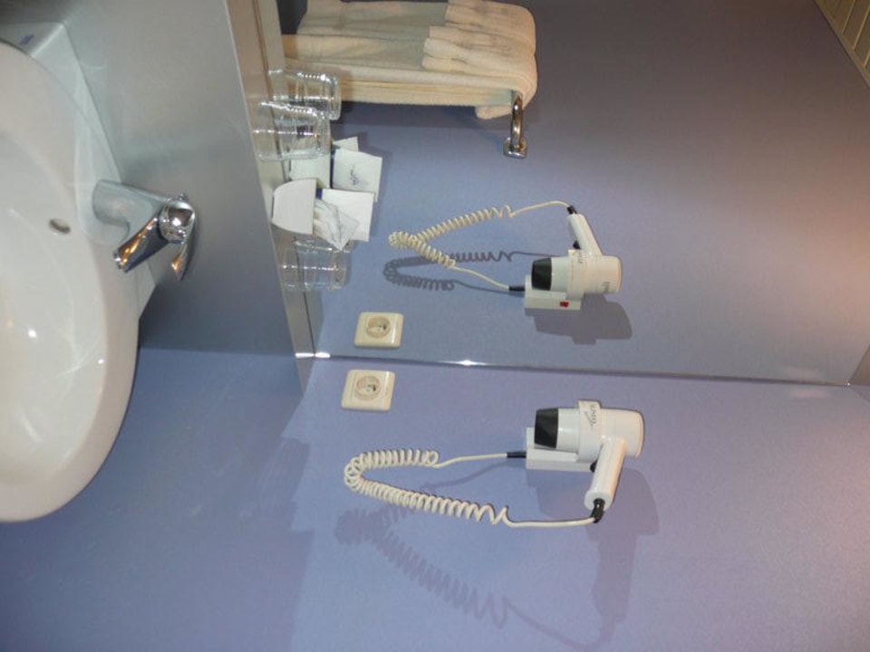 Blick ins Bad auf Fön und Spiegel Hotel Alfa Inn