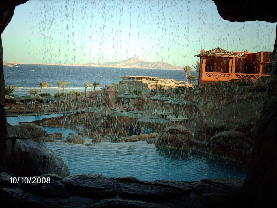 Blick durch den Wasserfall auf Poolandschaft Hotel Hauza Beach Resort