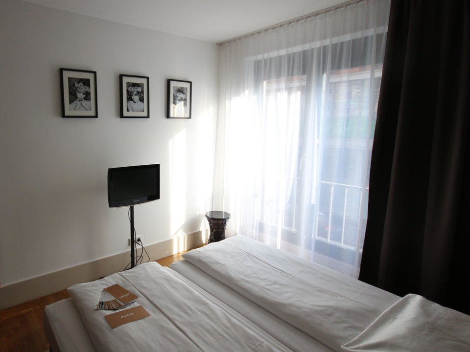 Doppelbett und Fernseher im Zimmer 110 Hotel AMANO