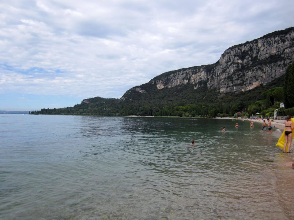Kiesstrand umrahmt von Bergen Hotel Marco Polo