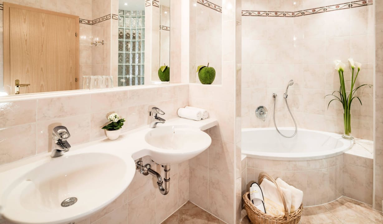 Badezimmer mit Dusche, Bad, Doppelwaschbecken Hotel Tyrol