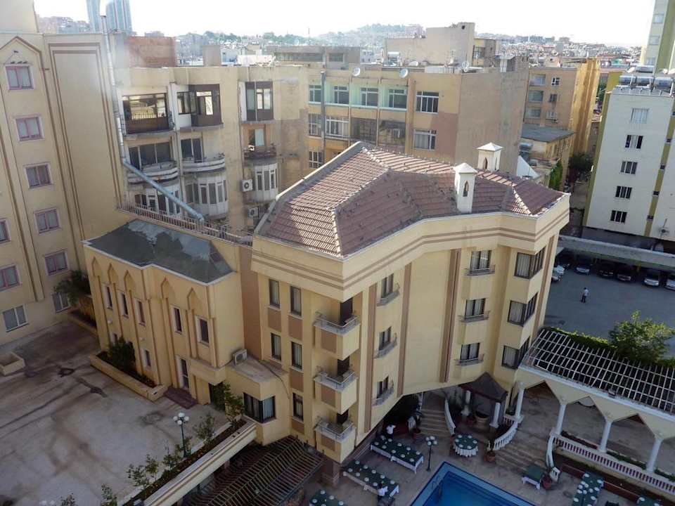 Blick auf Pool und fürs Abendessen gedeckte Tische Hotel Harran