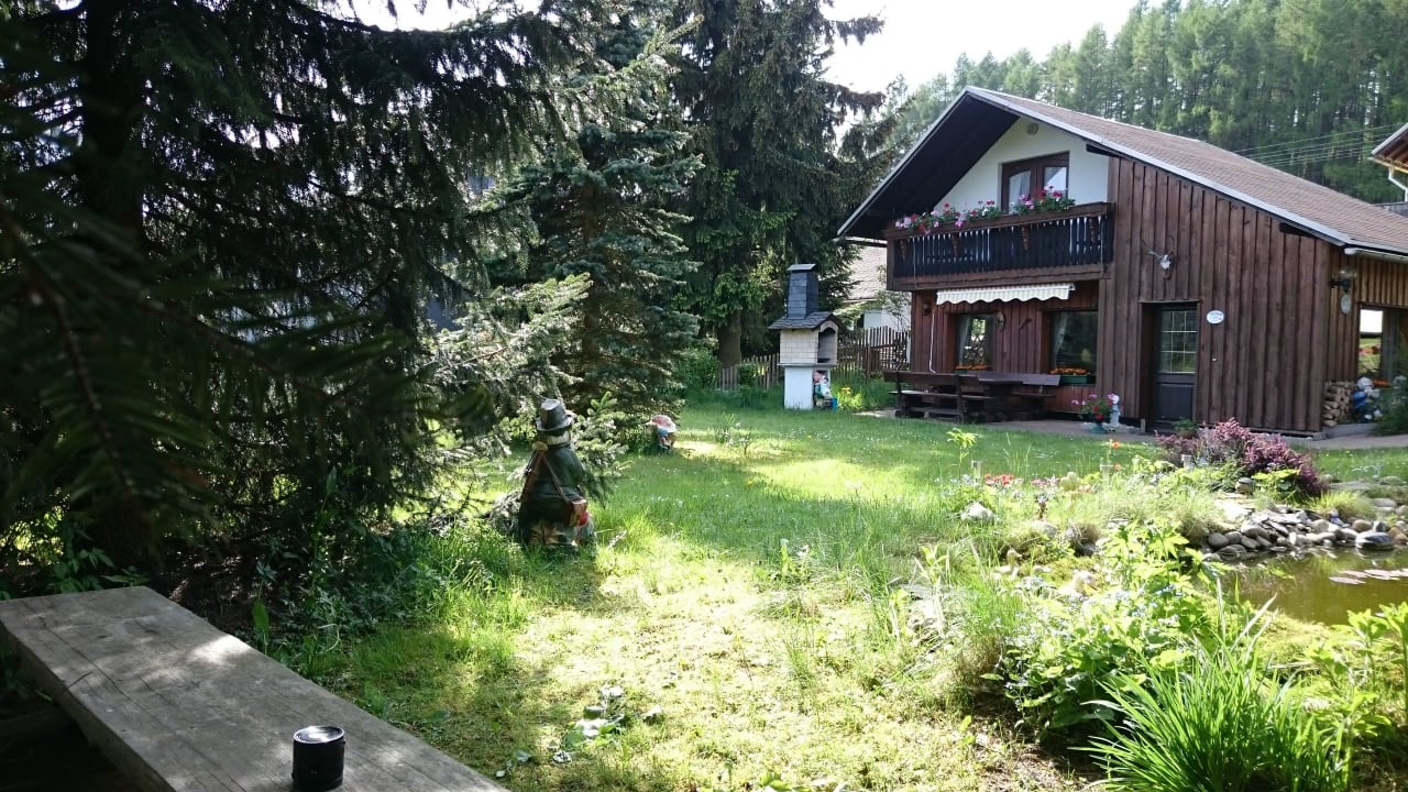 Bank am Seerosenteich mit Blick auf das Ferienhaus Apartment Panoramablick
