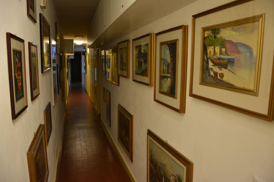 Hotelowy korytarz z małą galerią obrazów Hotel Caravella