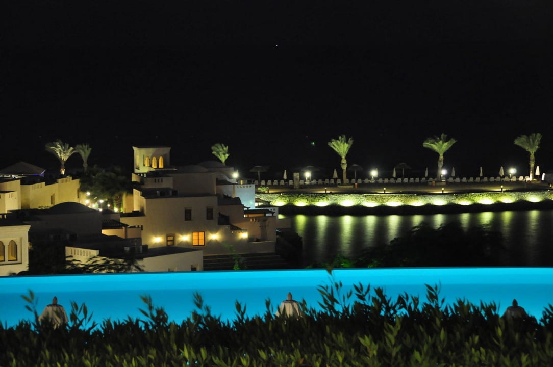 Blick über das Sunset-Pool Richtung Meer bei Nacht The Cove Rotana Resort