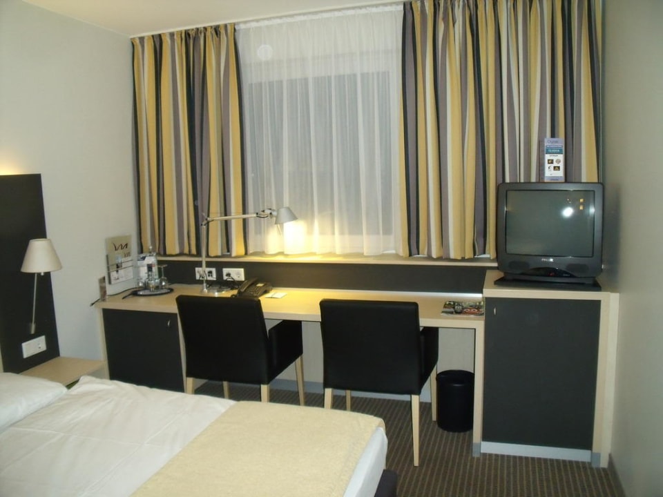 Bett und Ablage mit TV Mercure Hotel Berlin City