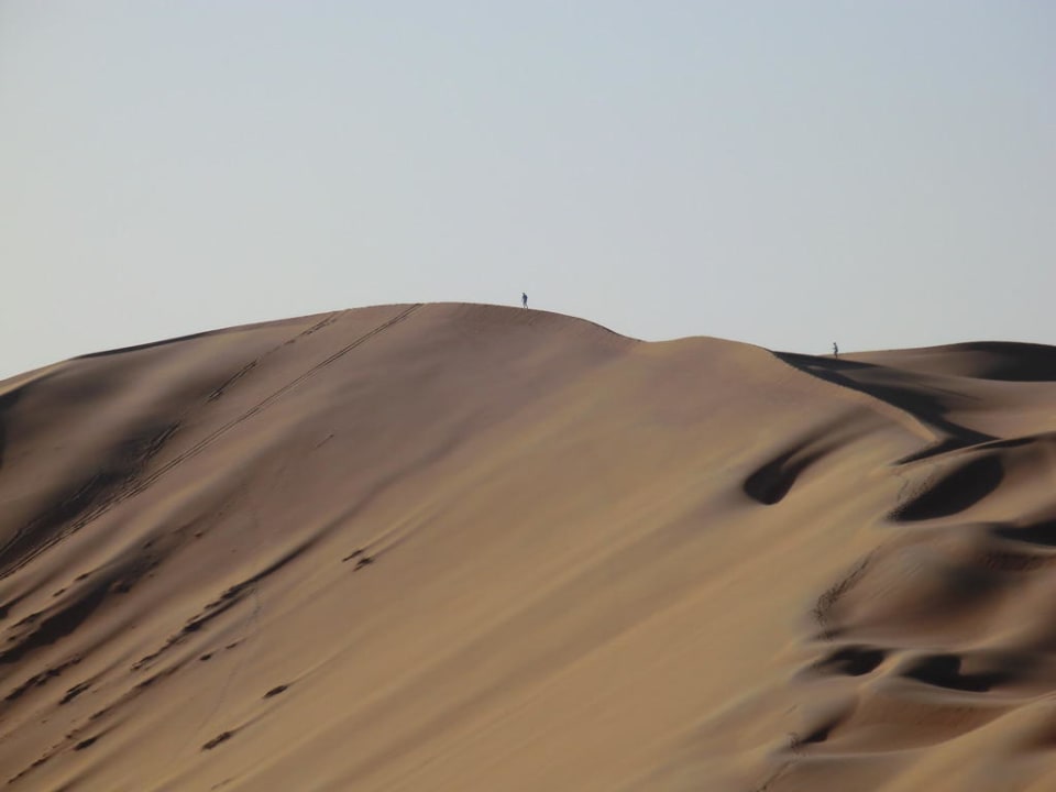 Die Hauptdüne vor dem Hotel mit Kletterlustigen Qasr Al Sarab Desert Resort by Anantara