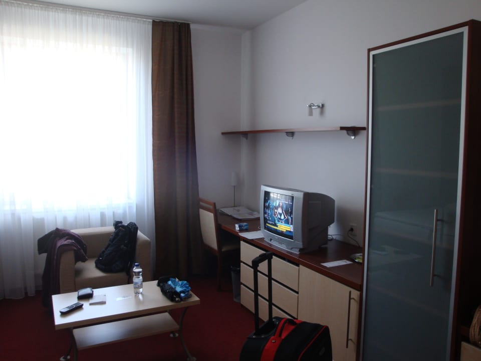 Tisch, Sitzgelegenheit und Fernseher Hotel Color