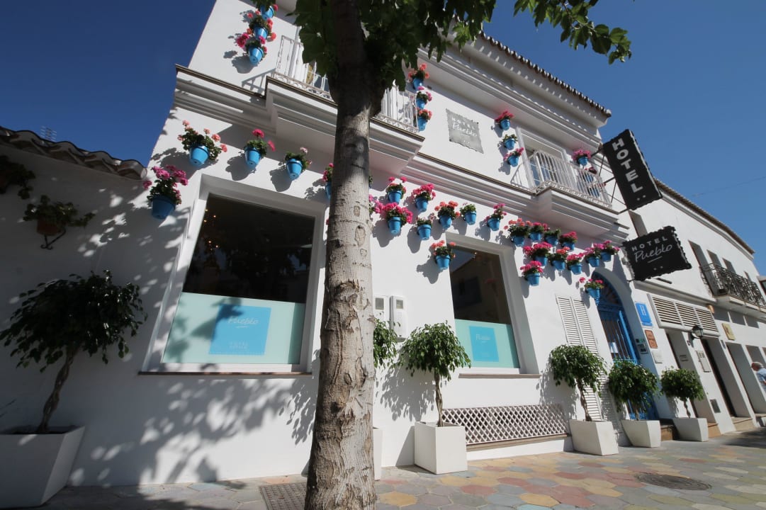 Hotel-Fassade mit blauen Blumentöpfen Hotel Pueblo