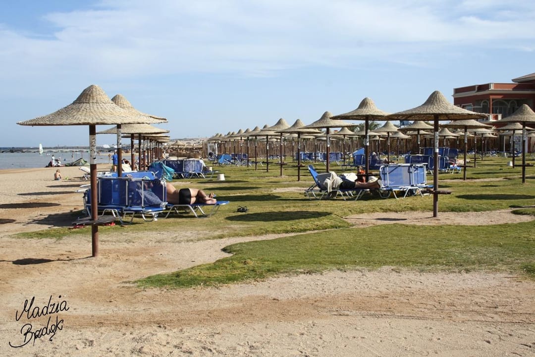 Stoliki i parasolki na plaży JAZ Aquamarine Resort