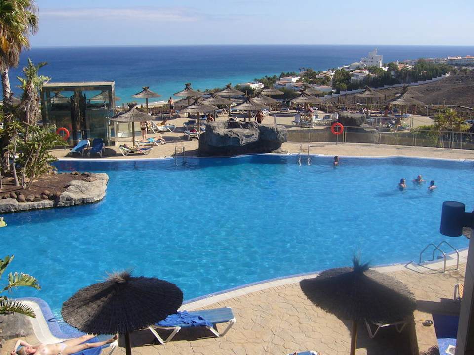 Der Pool mit Sonnenliegen und Sicht auf das Meer AluaVillage Fuerteventura