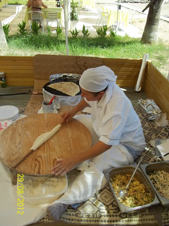 Frau macht Fladen am Strand Asteria Collection Side