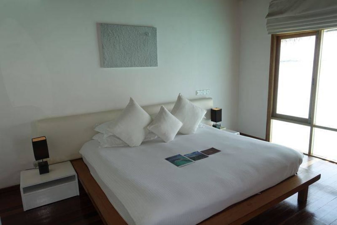 Bett in der Wasservilla Outrigger Maldives Maafushivaru Resort