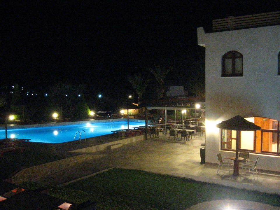 Blick auf Pool und Restaurant bei Nacht Alianthos Garden Hotel