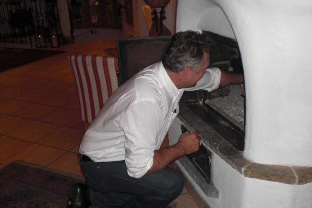 Der Chef macht das Kamin Feuer an Hotel Central