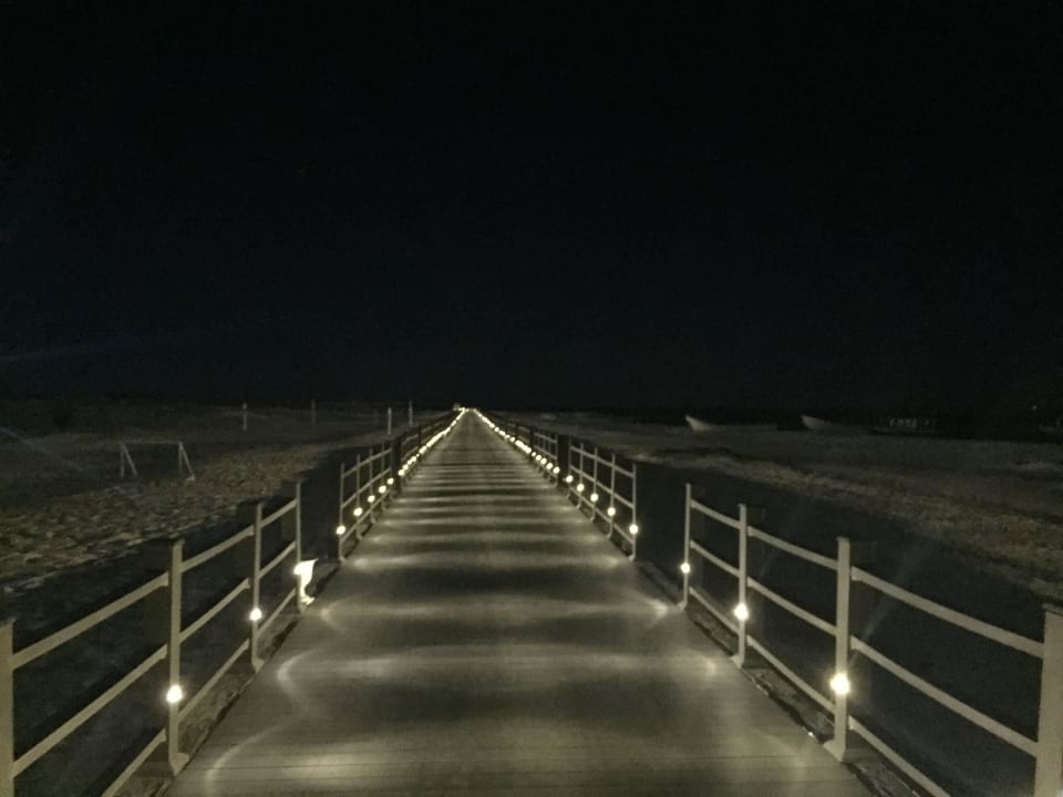 Beleuchteter Steg zur Badebucht Wyndham Garden Salalah Mirbat