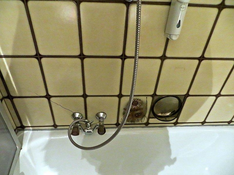 Das dunkle, beengte Bad mit rinnendem Wasserhahn Landgasthof Torrenerhof