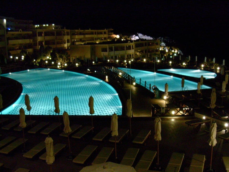 Poolanlage bei Nacht Hotel Kalithea Horizon Royal