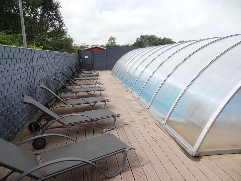 Pool mit Liegen, im Hintergrund die Sauna Hotel Aquarius