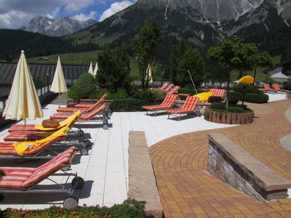 Kleiner Teil des Gartens mit Liegen Übergossene Alm Resort
