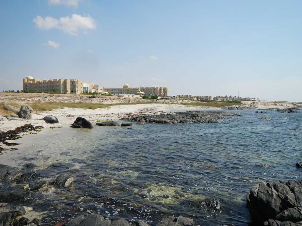 Blick vom Stand zum Hotel Wyndham Garden Salalah Mirbat