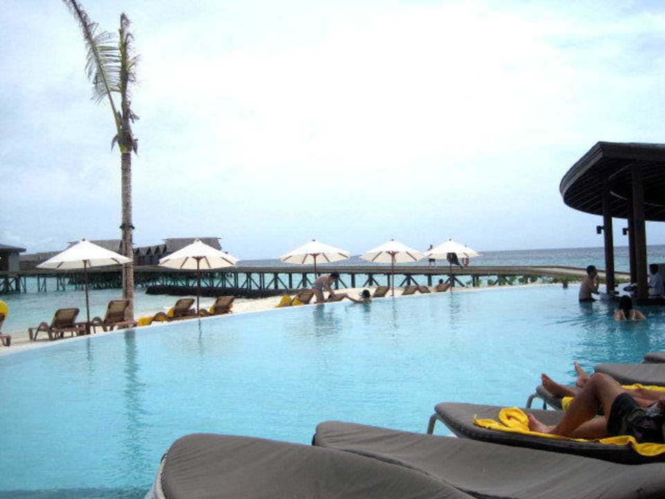 Der schoene Pool mit kleinen Boetchen ueber Wasser Centara Ras Fushi Resort & Spa Maldives
