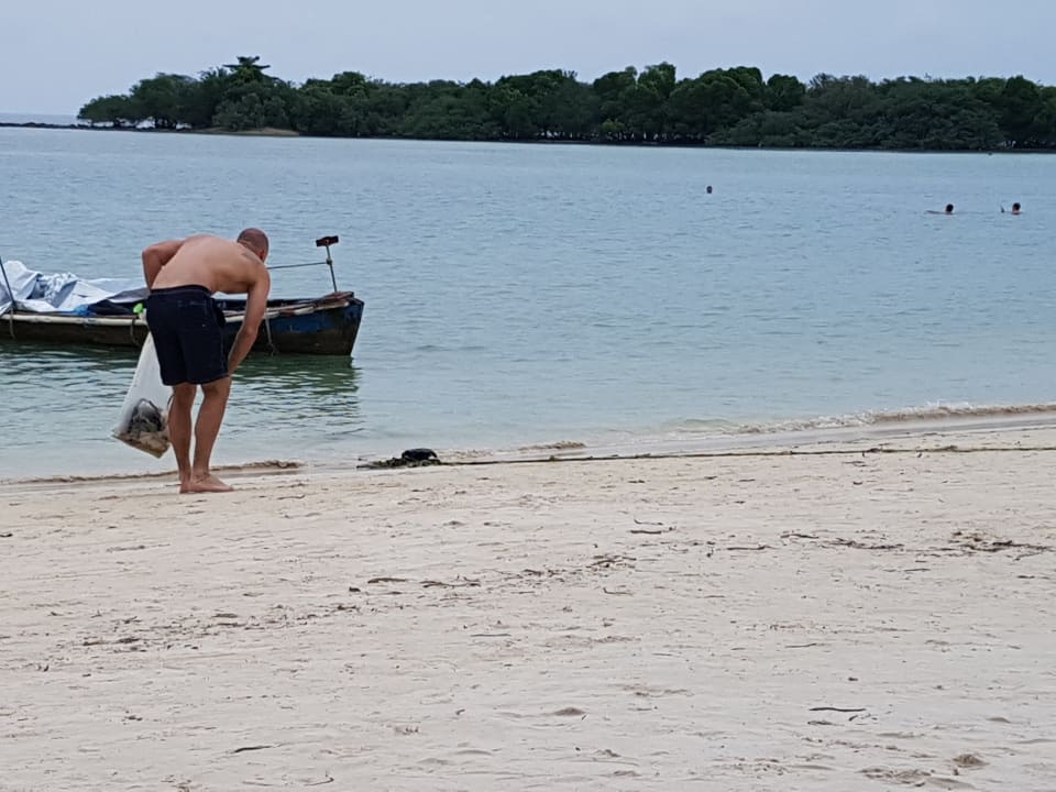 Tourist sammelt Müll am Strand  Iyara Beach Hotel