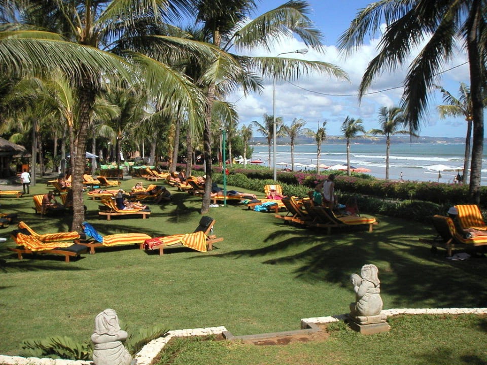 Schöne Wiese mit Liegen unter Palmen Bali Mandira Beach Resort & Spa