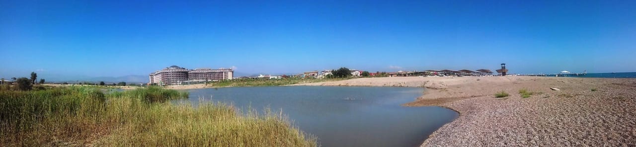 Panoramaaufnahme vom Strand bis zum Hotel Sunmelia Beach Resort