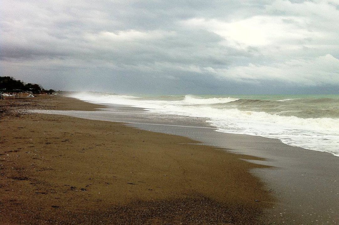 Menschenleerer Strand links vom Hotel Skys Hotel