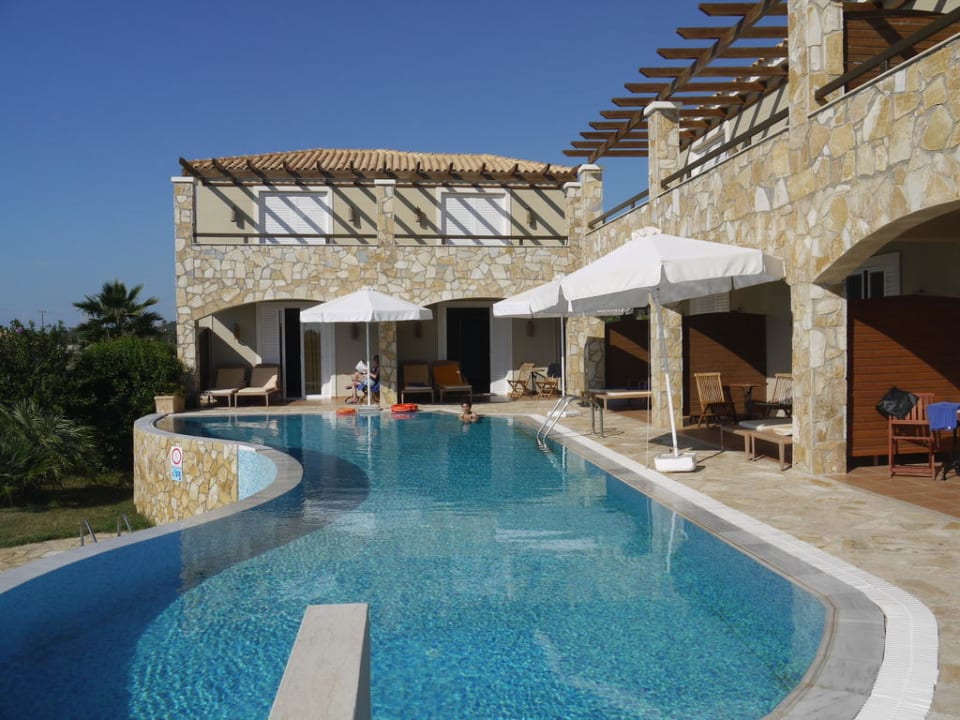 Blick über einen Pool zu den Bungalowzimmer Olympia Golden Beach Resort & Spa