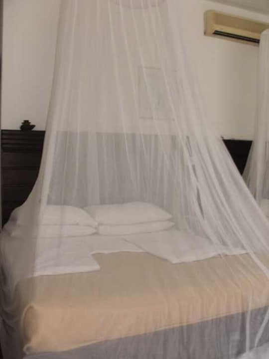 Kingsizebett mit Moskitonetzt und Klimanlage Travellers Beach Hotel & Club