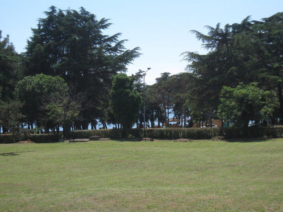 Der Park  am Hotel mit dem Strand im Hintergrund Valamar Parentino Hotel