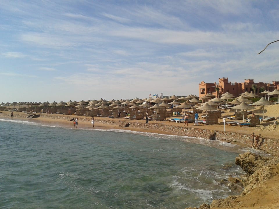 Blick auf Strand mit Sonnenschirm und Liegen Charmillion Sea Life Resort